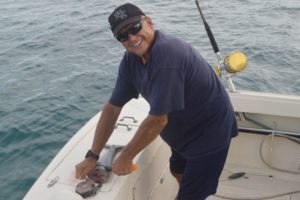 Commodore Chuck Gauthier chops up his piece of the wahoo. Photo: Karen Earnshaw